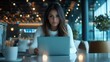 © basketman23 - Focused Woman Working on Laptop in Modern Office Setting