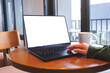 © Farknot Architect - Mockup image of a woman working and typing on laptop computer with blank white desktop screen