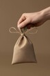 © Diffin - A tender moment captured as someone gently holds a charming small bag, adorned with a delicate string, perfect for Valentine's Day surprises.