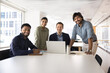 © fizkes - Four happy diverse co-workers standing together at workplace, looking at camera, smiling. Multiethnic team of cheerful young African, Indian, Caucasian professional colleagues office portrait