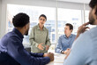 © fizkes - Inspired young Indian manager woman speaking to colleagues, telling creative ideas for business plan. Multiethnic team of coworkers meeting in conference room for teamwork, brainstorming