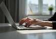 © Anomal - Female hands typing on laptop keyboard at the office. Wide