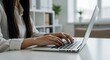 © Anomal - Female hands typing on laptop keyboard at the office. Wide