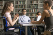 © fizkes - Social inclusion of people with disabilities. Teenage girl student wheelchair user lead group discussion seminar express idea to interested diverse multiracial mates on round table meeting at library