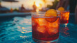 © CreativeIMGIdeas - Sunset Spritz:  Two glasses of refreshing Aperol Spritz, adorned with orange slices, sit invitingly on a poolside table, bathed in the warm glow of a setting sun.