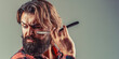 © Yevhen - Hairdresser shaving with straight razor. Hairstylist with vintage straight razor. Attractive macho in shirt with straight razor near his beard. Copy space