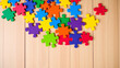 © Jonathan - Top view of bright multicolored pieces of puzzle on wooden background, autism concept