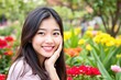 © ThomasLENNE - Portrait of happy asian girl looking at camera and smiling in garden