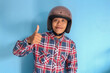 © Lailar Studio - Young Asian man wearing motorbike helmet giving 'thumb up' fingers sign
