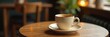 © Sathaporn Buarabut - Warm beige cup filled with dark liquid on a small wooden table in a cozy cafe atmosphere , , brown liquid