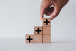 © Pakorn - Positive Sign,growth mindset,opportunities,added value concept.,Hand arranging wooden cube with plus sign icon idea for growth in personal and professional development.