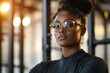 © c80 - Confident young woman with glasses posing in a modern gym setting during a workout session