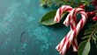 © Sathaporn Buarabut - White and red striped candy canes on a branch, festive holly, festive treats, holiday decor