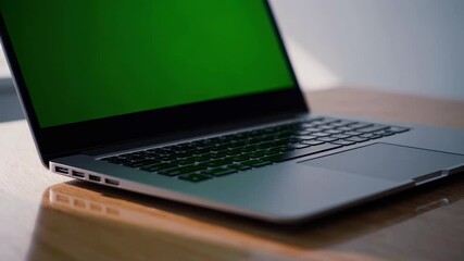 Poster - Modern laptop on wooden table with green screen ready for productivity or creative projects
