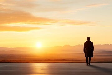 Wall Mural - Man standing alone at sunset overlooking mountains and valleys in serene landscape