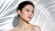 © QuickDesign24 - Young Asian woman with flawless skin natural makeup soft lighting gentle touch serene expression beauty portrait clear complexion minimalist background