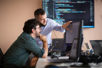 programmers engrossed in deep collaboration, diligently working together to solve complex problems