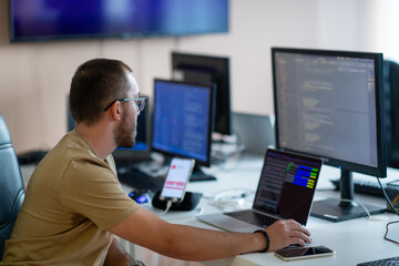 a programmer diligently testing smartphone applications while sitting in their office.
