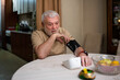 © romul014 - Senior man using medical device to measure blood pressure at his home.