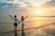 © Kittiphan - Young couple traveler looking beautiful sunset on the beach, Couple on vacation in summer concept