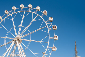 Part of the Ferris wheel against the blue sky. Attractions and entertainment.