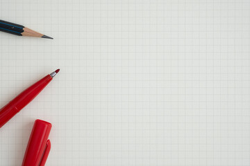 Wall Mural - top view, close-up of red felt-tip pen and pencil on graph paper, copy space for text, flat lay conc