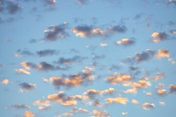 Wall Mural - A beautiful sky tinted by the sun leaving vibrant shades of gold, pink, blue and multicolored. Clouds in the twilight evening and morning sky. Cloudy sky background in the evening, and during the day.