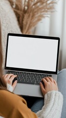 Wall Mural - woman sitting on a comfortable sofa at home, typing on a laptop computer with a blank white screen, 
