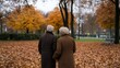 © Iona - An elderly couple strolls hand-in-hand through an autumn park, surrounded by golden leaves, embodying timeless love and tranquility.