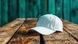 ©  Shomixer - A minimalist shot of a classic white baseball cap set against a rustic wooden table, offering a blend of modern fashion and natural earthy textures in the composition.