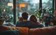 © DIAHIMAGESNEW - Couple and dog cuddling on sofa, rainy view.