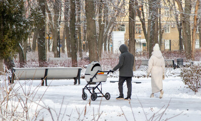 A man pushing a stroller with a baby in it