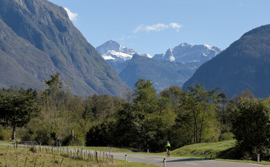 bicycle rider cycling on an empty road in the mountains of julian alps (bovec, slovenia, europe, alpine mountain scenery) biking in scenic european travel adventure getaway