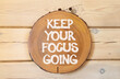 © Dzmitry - Keep your focus going symbol. Concept words Keep your focus going on beautiful wooden circle. Beautiful wooden wall background. Business and keep your focus going concept. Copy space.