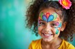 © Viktor - Young girl with colorful face paint indoors. Artist creates intricate design on child face. Happy expression on childs face. Likely kids party carnival event. Capture child fun in festive environment.