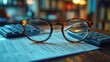 © Ummeya - Eyeglasses rest on documents and calculators.