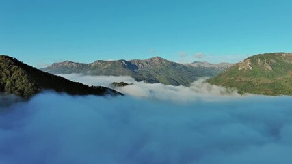 Wall Mural - flying between the clouds. aerial view of clouds and mountains at sunrise. traveling by air backgrou