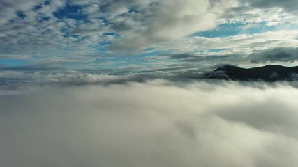Wall Mural - flying between the clouds. aerial view of clouds and mountains at sunrise. traveling by air backgrou