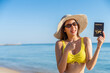 © CandyRetriever  - Happy Asian woman travel nature the sea on summer beach holiday vacation. Portrait of Smiling Attractive girl in beach clothing holding passport during relaxing on tropical island beach in sunny day.
