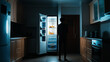 © kaliel - A man stares into a fridge pondering his late night snack options
