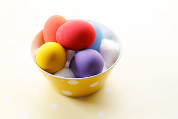 Wall Mural - Happy Easter eggs in a bowl on dot yellow color background.