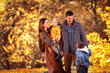 © Mediteraneo - Lovely family in autumn park, young parents with nice adorable kids playing outdoors