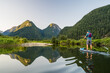 © Cavan Images - Man paddling SUP on relaxing calm water with mountain view