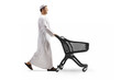 © Ljupco Smokovski - Full length profile shot of a young muslim man walking and pushing a shopping cart