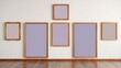 © Akaligo Stock - Empty wooden frames on a wall in a room with hardwood floors