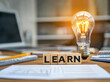 © JM Nimhas - Light bulb with the word LEARN written in wooden blocks, symbolizing education, knowledge, and enlightenment