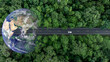 © Kalyakan - Aerial view EV electric vehicle car on middle green tree forest road globe earth planet, EV car electric vehicle car alternative sustainable energy eco power, Green business ecosystem environment.
