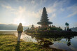 © Matteo Colombo - Woman standing in front of hindu temple on lake Bratan, Bali, Indonesia