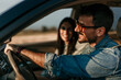 © La Famiglia - Happy couple driving together, enjoying a scenic sunset on a road trip