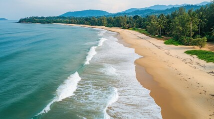 Aufkleber - Aerial view of serene tropical beach with gentle waves cascading onto golden sandy shore surrounded by lush greenery and distant mountains